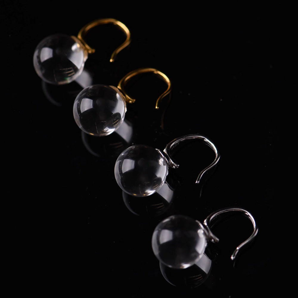 Close up of polished clear quartz bead and gold plated silver ear hook
