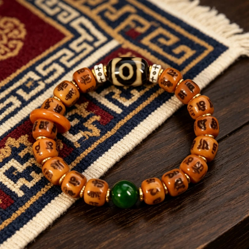 Hand carved Tibetan six syllable mantra Yak bone bracelet with dzi bead placed on traditional Tibetan rug, boho spiritual bracelet