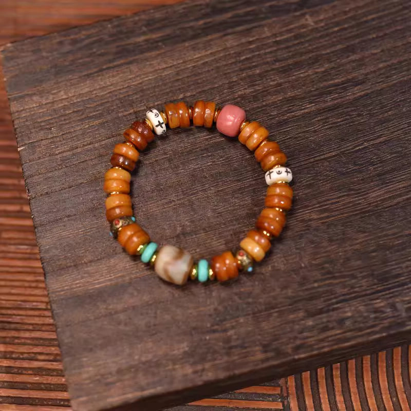 Crafted from ox bone, turquoise, and dzi beads, it aims to bring protective blessings to the wearer.