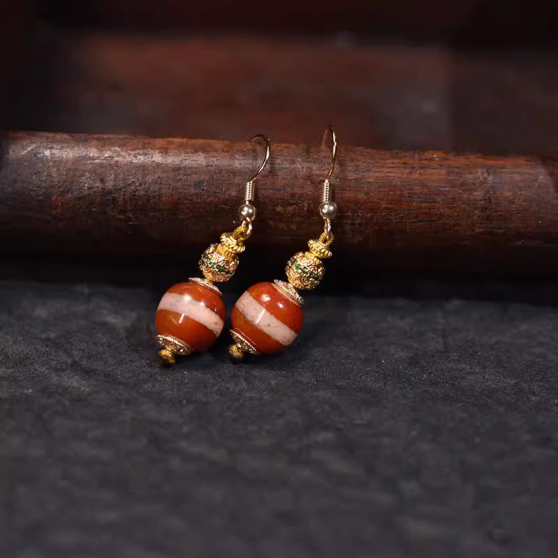 Crafted with orange-and-white dzi beads and golden decorative beads, these earrings boast a minimalist design with retro charm, blending ethnic style and luxury vibe. They exude elegance when worn.
