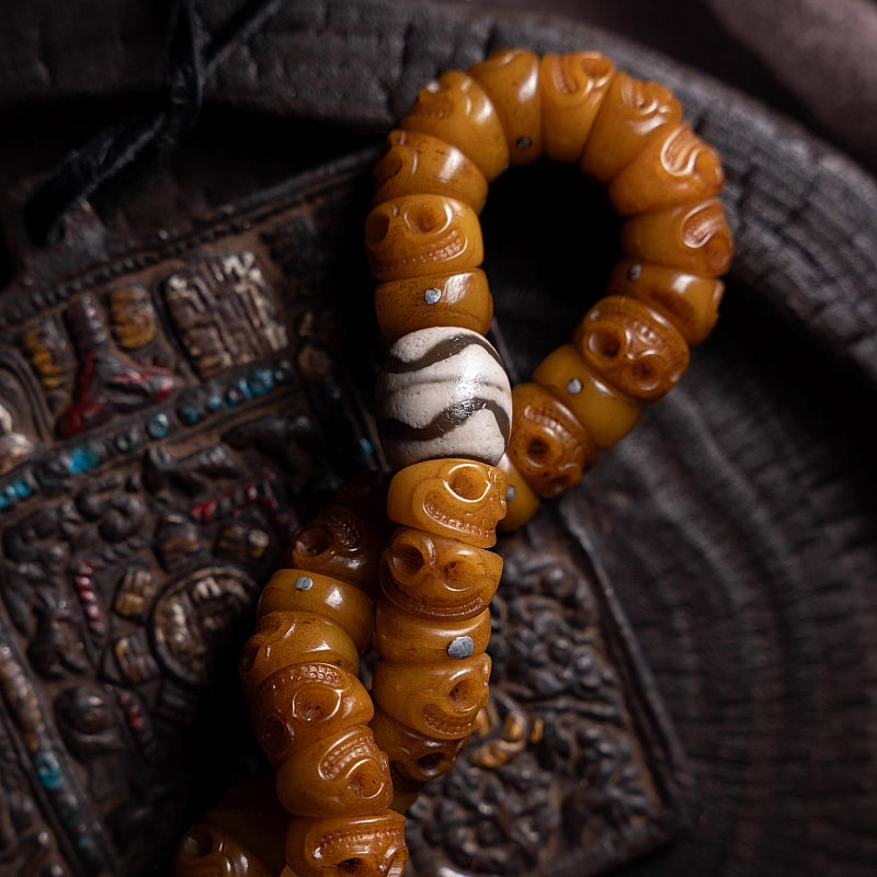 Detailed macro shot of authentic Tibetan yak bone jewelry, highlighting the naturally aged amber-colored beads and distinct cultural patterns.