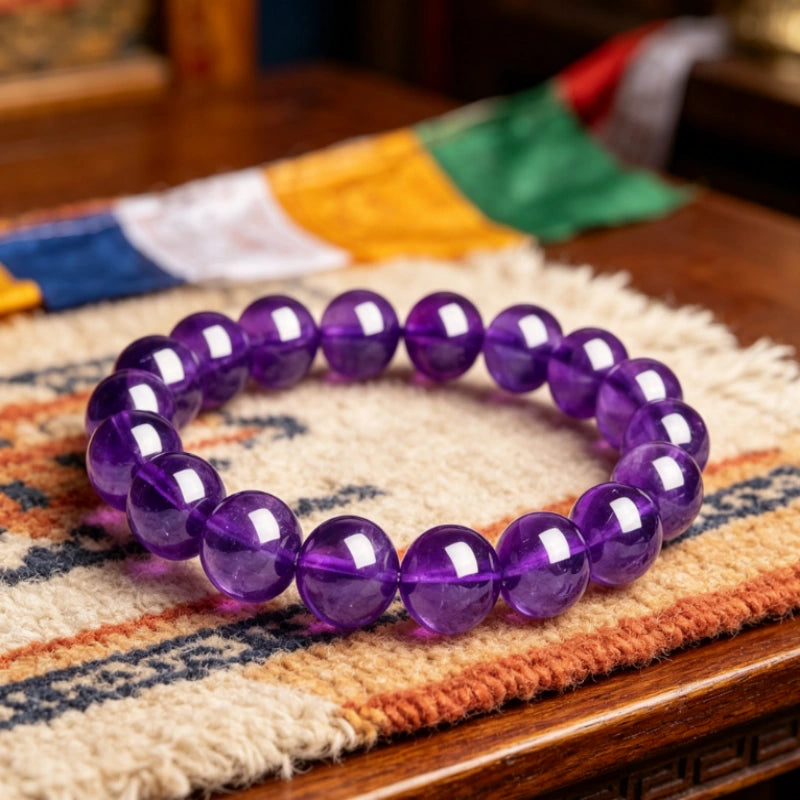Handcrafted natural amethyst prayer beads resting on traditional Tibetan woven rug, spiritual healing jewelry for inner peace.