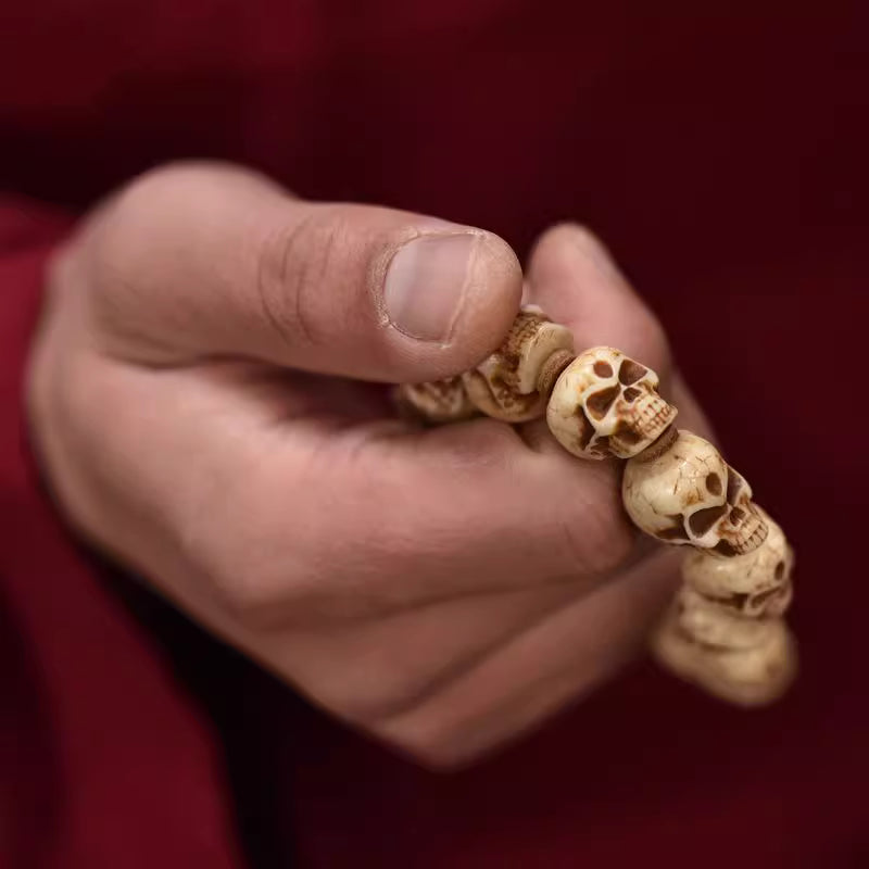 Close-up of hand carved Citipati skull beads natural Tibetan yak bone bracelet detail