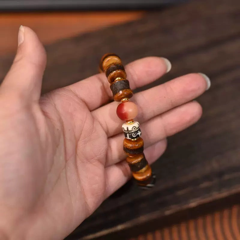 Hand polished natural yak bone bracelet close-up, tibetan dzi stone accent unisex elastic single strand mala