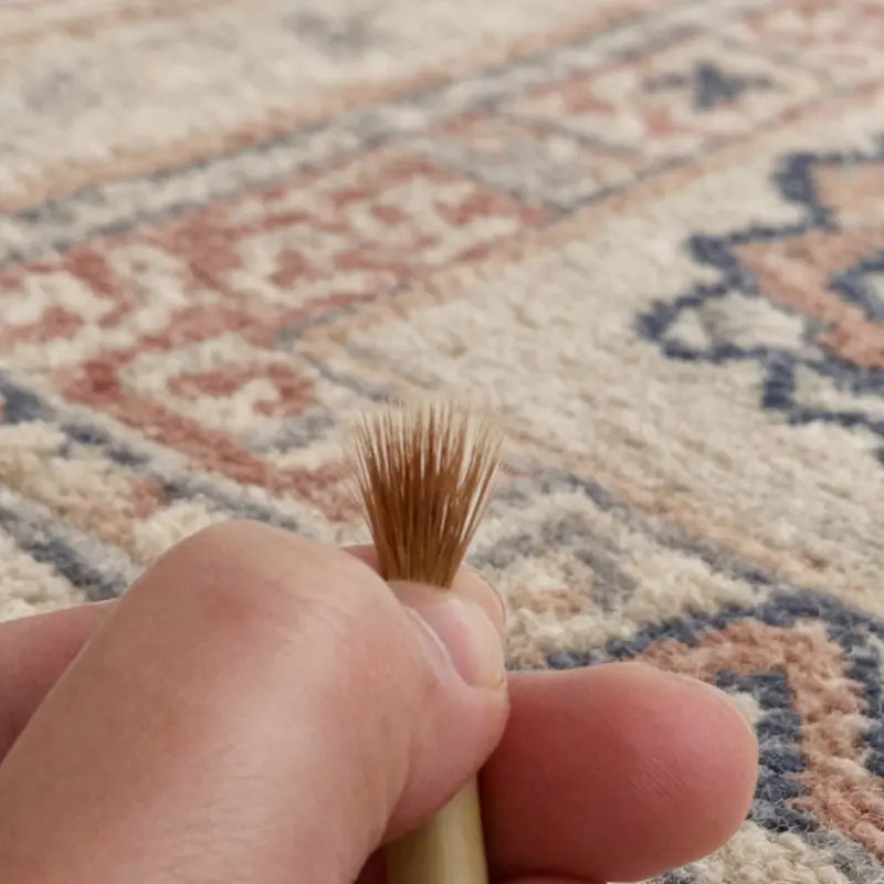 Hand holding liner brush showing fanned weasel hair bristles
