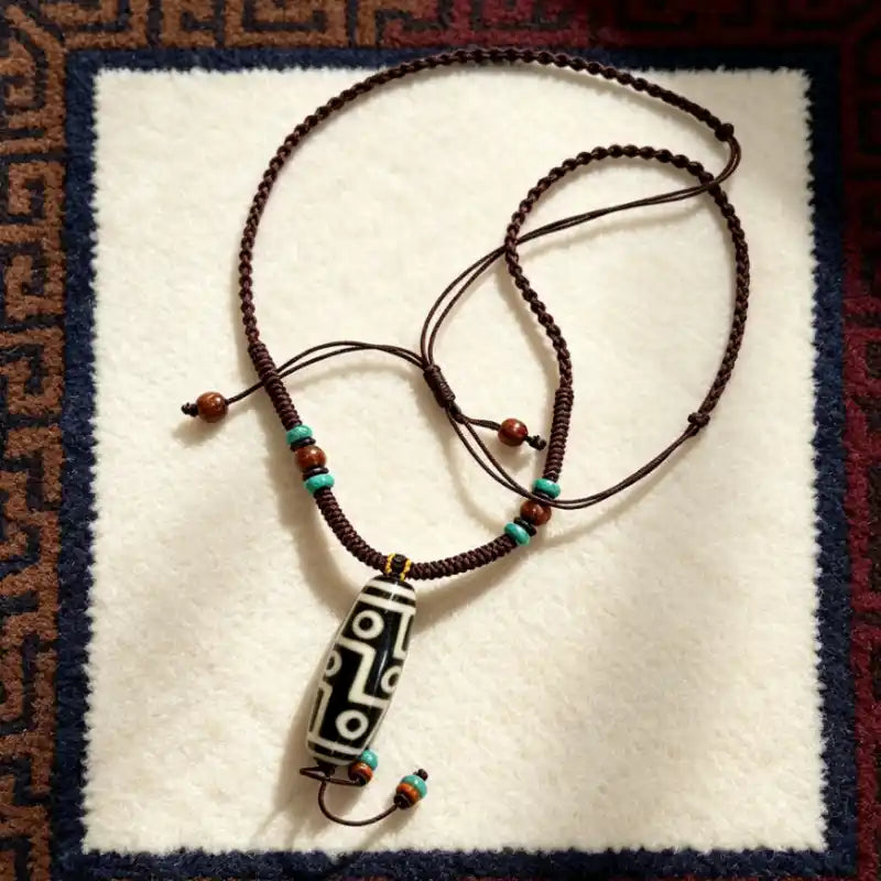 Agate Dzi Bead pendant with turquoise-tone and wooden accent beads on a braided cord