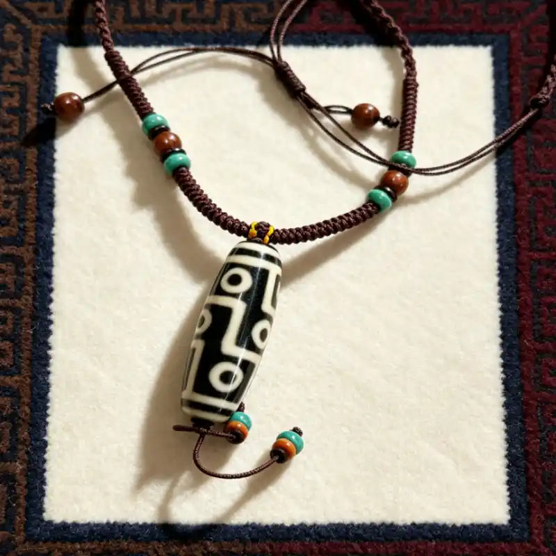 Agate Dzi Bead pendant with turquoise-tone and wooden accent beads on a braided cord