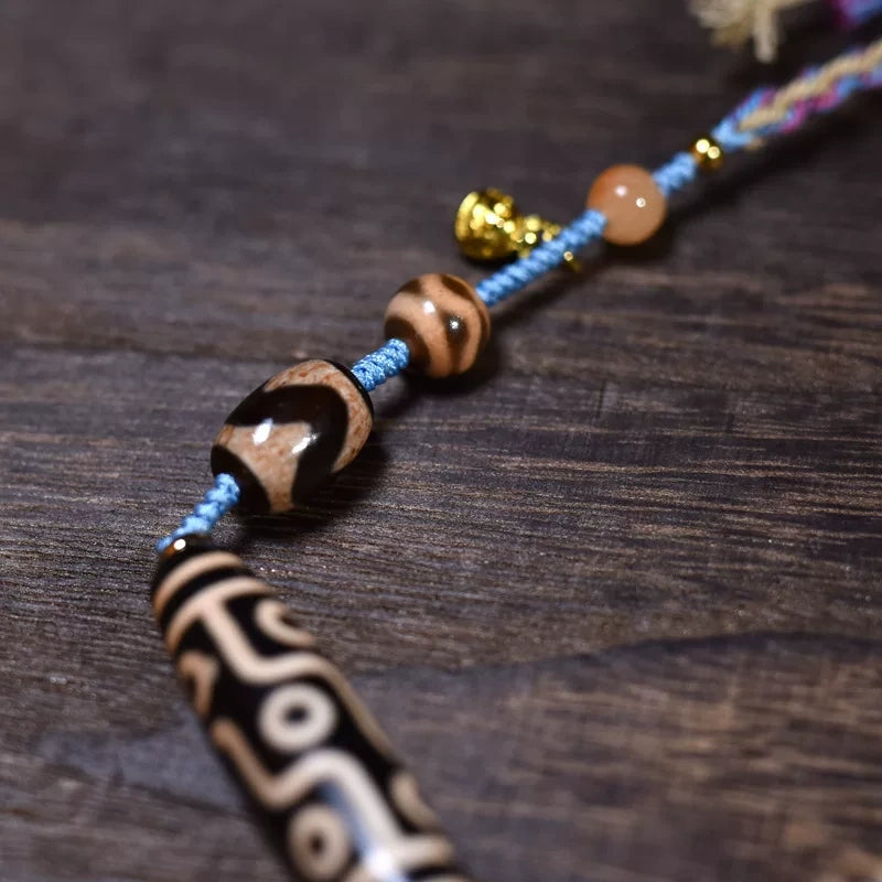Close-up of hand-carved nine-eye dzi bead pattern on Tibetan Buddhist necklace