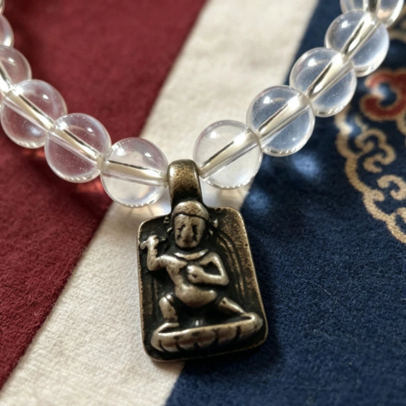Close-up of Tibetan silver guardian deity charm on 8mm clear quartz beads