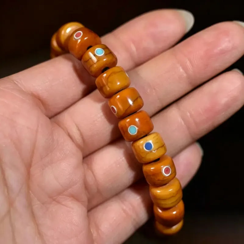 Close-up of Tibetan yak bone bracelet beads with turquoise and red agate inlay detail