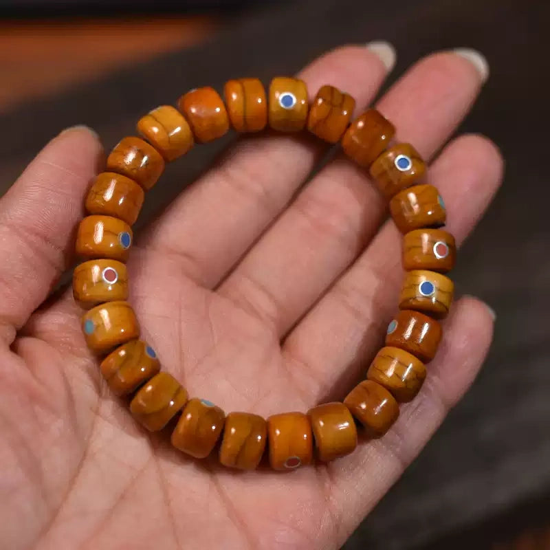 Handmade Tibetan yak bone bracelet with colorful inlay beads held in palm
