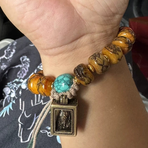 Wearing shot of vintage natural yak bone mala bracelet on wrist, Tibetan unisex spiritual protection bracelet with dzi bead and gawu charm for everyday peace