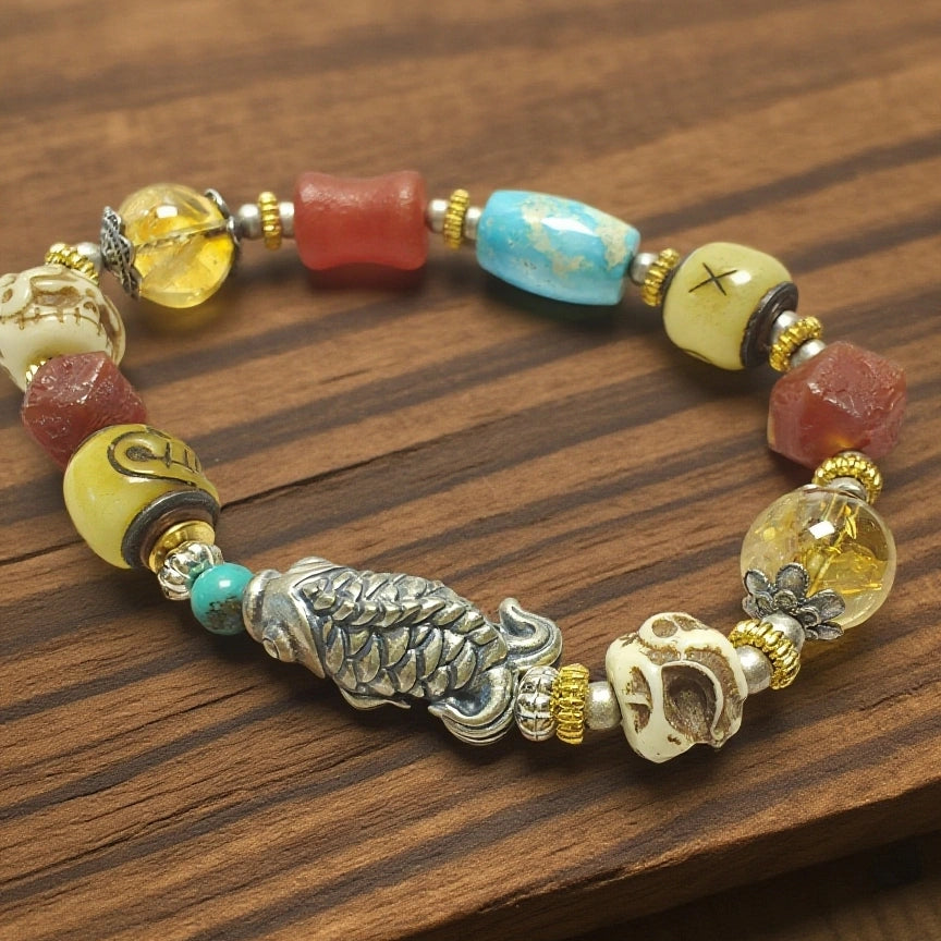 Close-up of silver fish charm bracelet, Tibetan Buddhist auspicious symbol detail