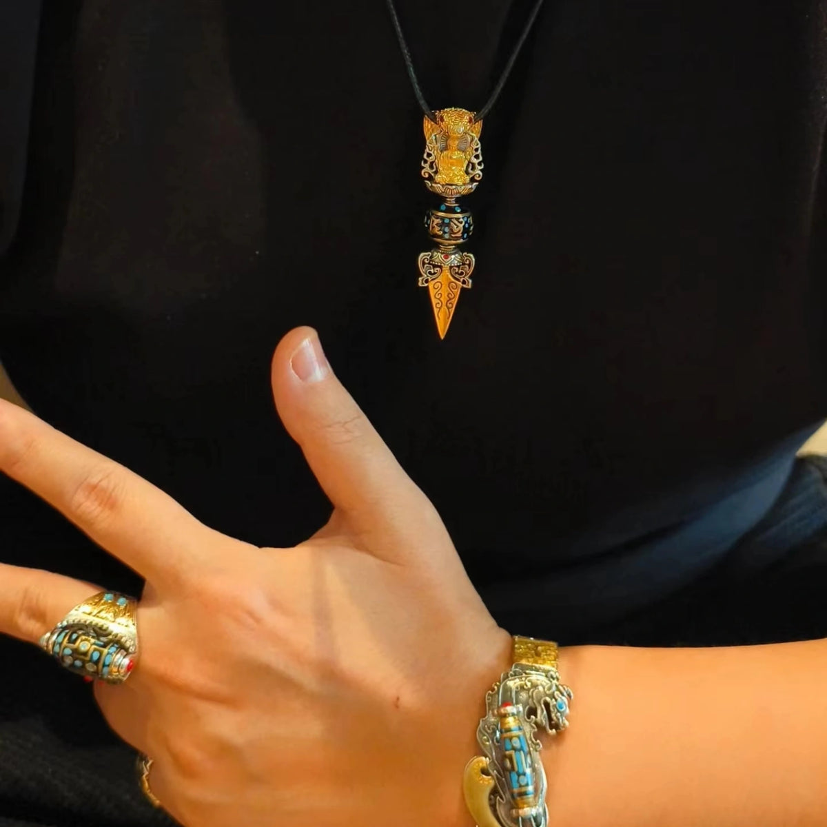 Hand holding rotatable spiritual talisman necklace, stress relief wearable meditation charm