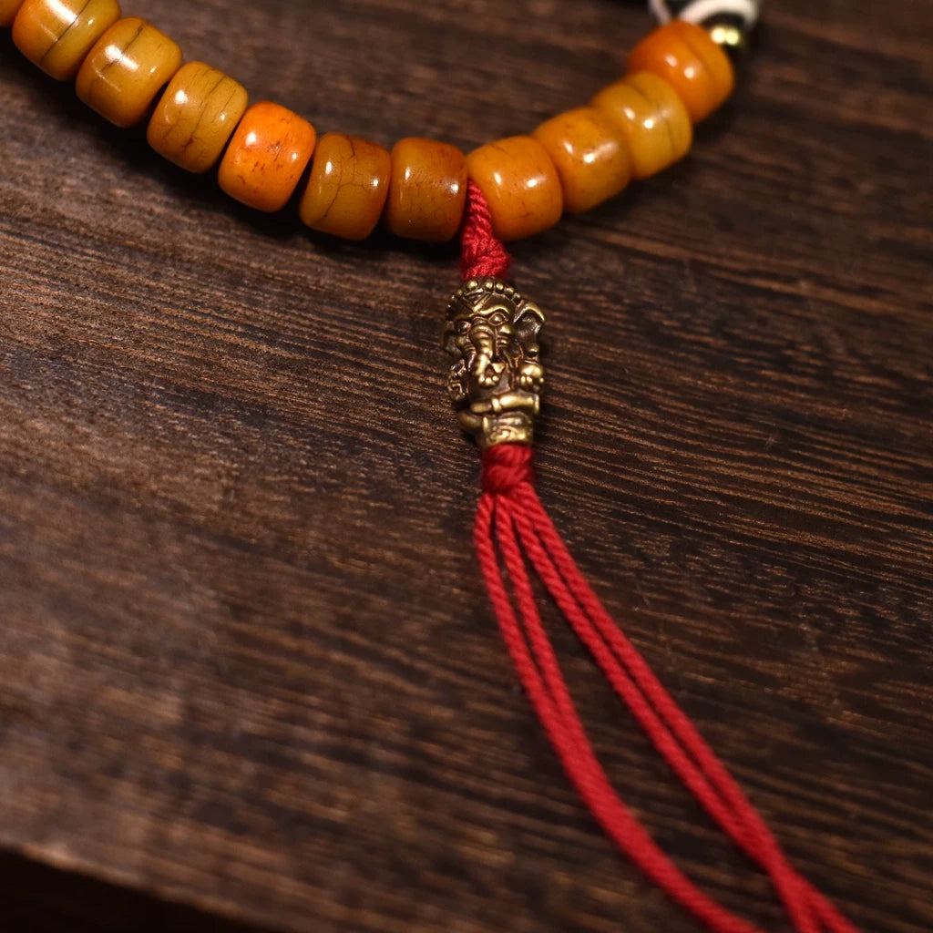 Close-up of the tassel and dzi bead charm on this spiritual 108 yak bone mala