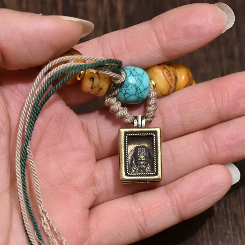Close-up view of Tibetan natural yak bone bracelet, focus on tiny wearable Zhaji Lhamo gawu box and natural turquoise ornament, soothing spiritual wrist accessory